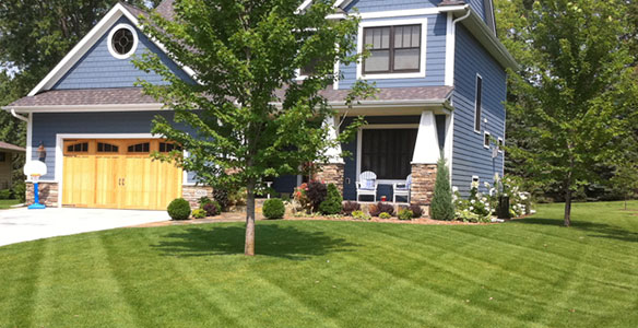 Professional lawn mowing service in Minneapolis Minnesota showing freshly cut Kentucky Bluegrass lawn with commercial mowing equipment